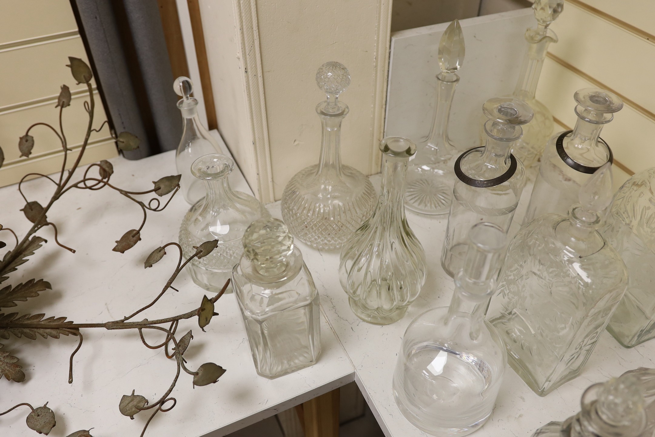 A quantity of various glass decanters, some silver mounted